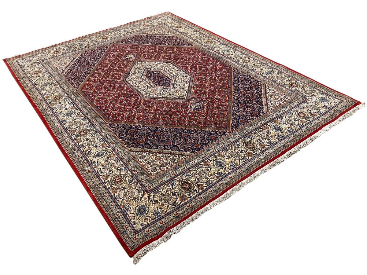 Vloerkleed met rood middenmotief, lichte sierlijnen en een brede, ornamenteel gedessineerde rand
