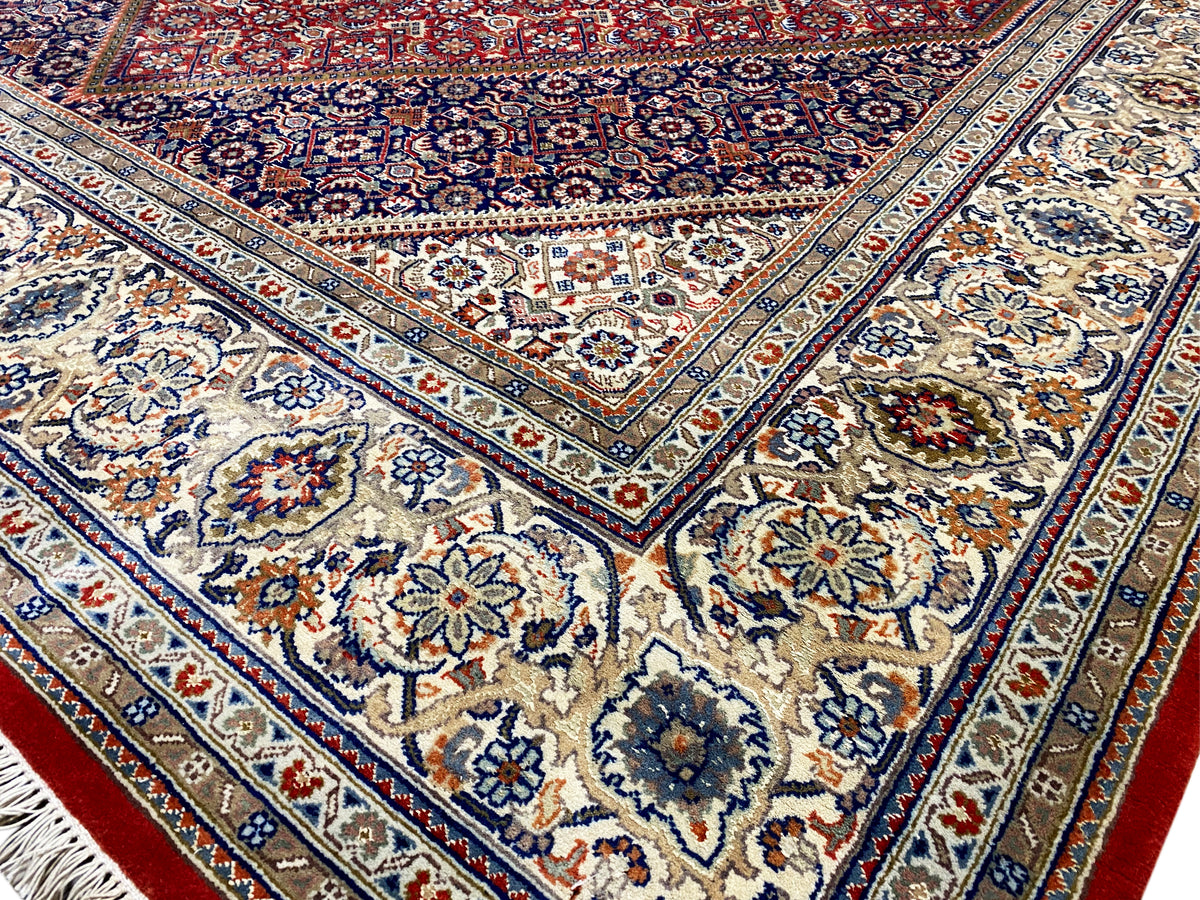 Detailweergave: blauw centrum met florale motieven, omlopende ornamenten en rode accenten