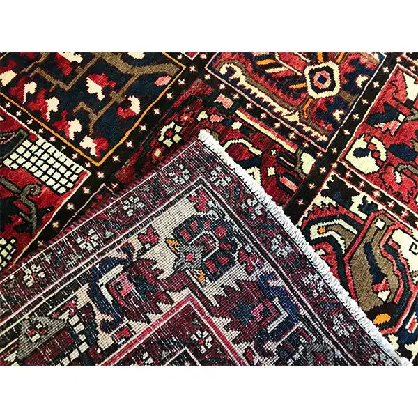Close-up van Oosters tapijt Bakhtiari: diverse motieven, ruiten en trapmotieven in donkerrood