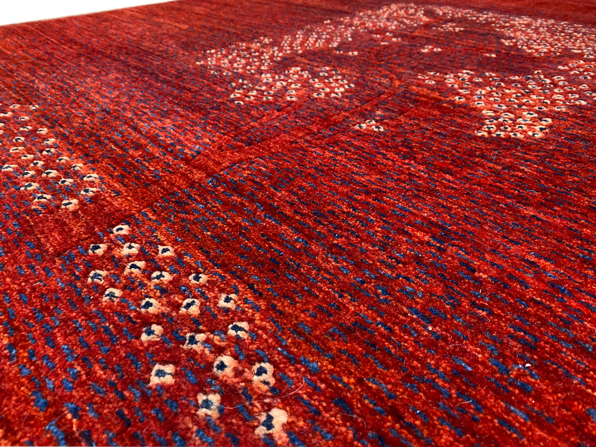 Detail van rood tapijt met randindeling en medaillonpatroon in stippelweergave