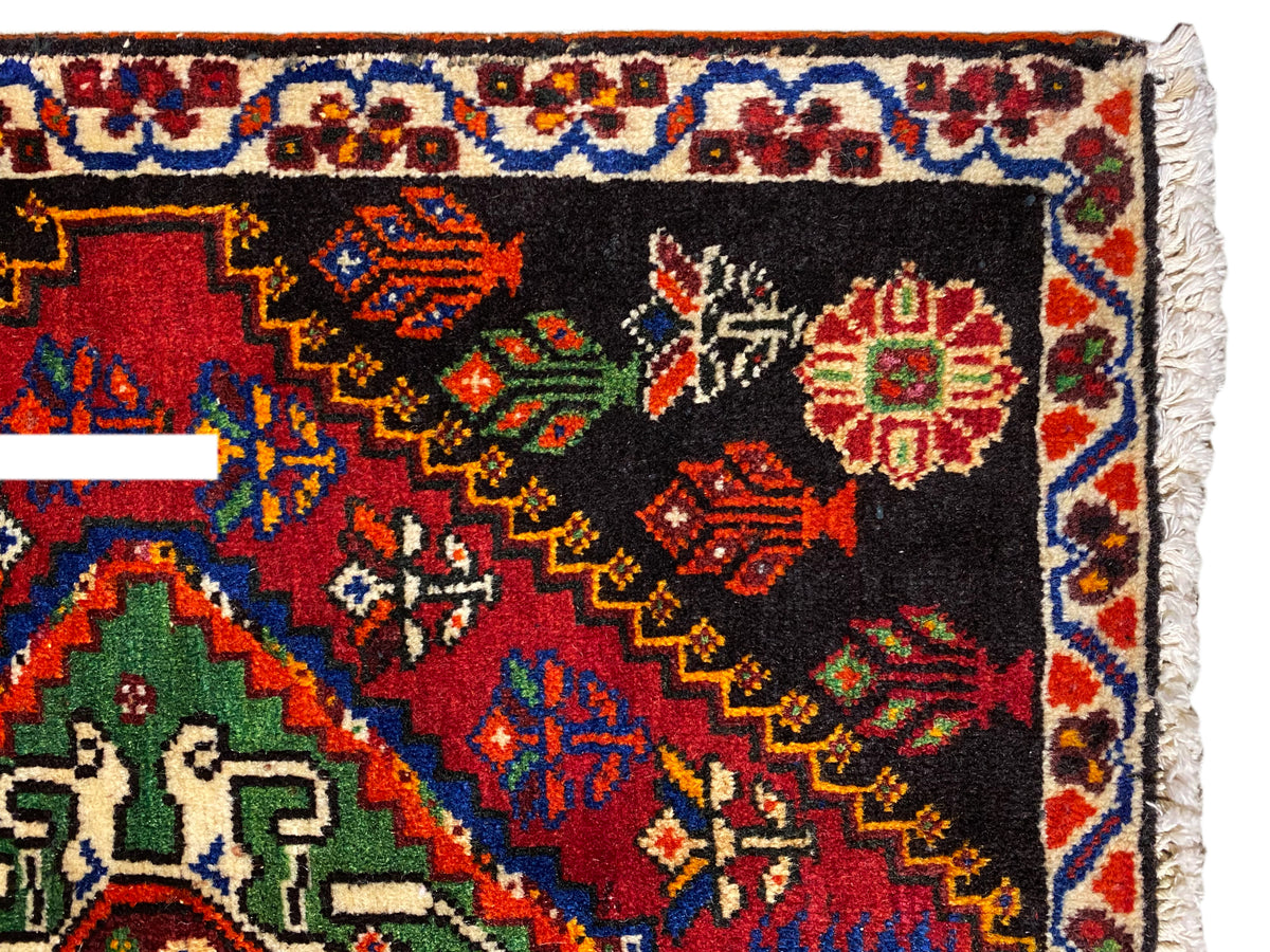 Poshti-tapijt 56x56 cm close-up: ornamentrand met gekleurde ruiten op een zwarte ondergrond