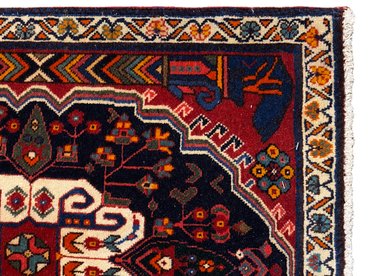 Poshti-tapijtrand in close-up met kleurrijke ornamenten en een donker binnenveld