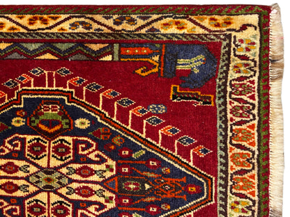Detail van het Poshti-tapijt (59×61 cm): rood veld met tapijtornamenten en een omboorde rand
