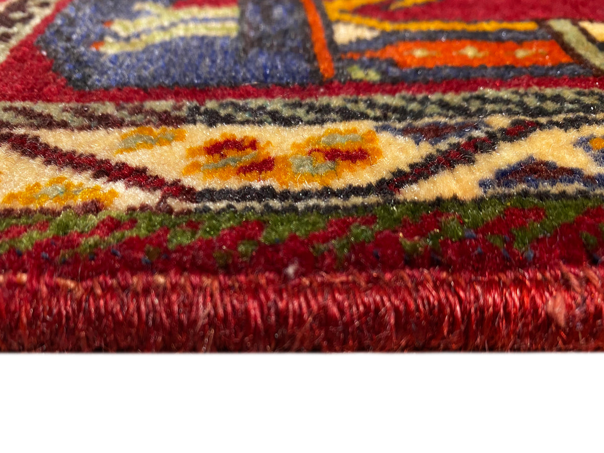 Poshti-tapijt (59×61 cm) close-up: rode poolhoogte en kleurrijke randen met franjes