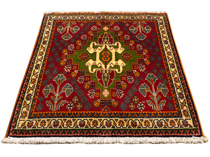 Oosters tapijt met rood middenmotief, groene details en beige rand, met franjes