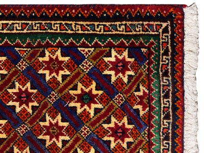 Poshti-tapijt 62x52 cm close-up: rand, rood/blauw-groene patronen en witte franjes.