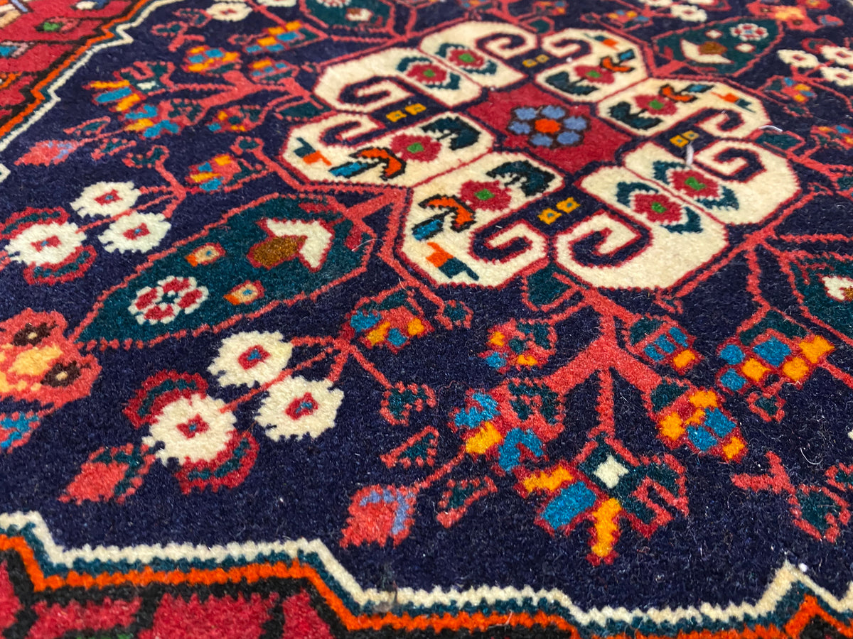 Close-up of carpet pile with colorful ornamentation in blue, red, cream and green