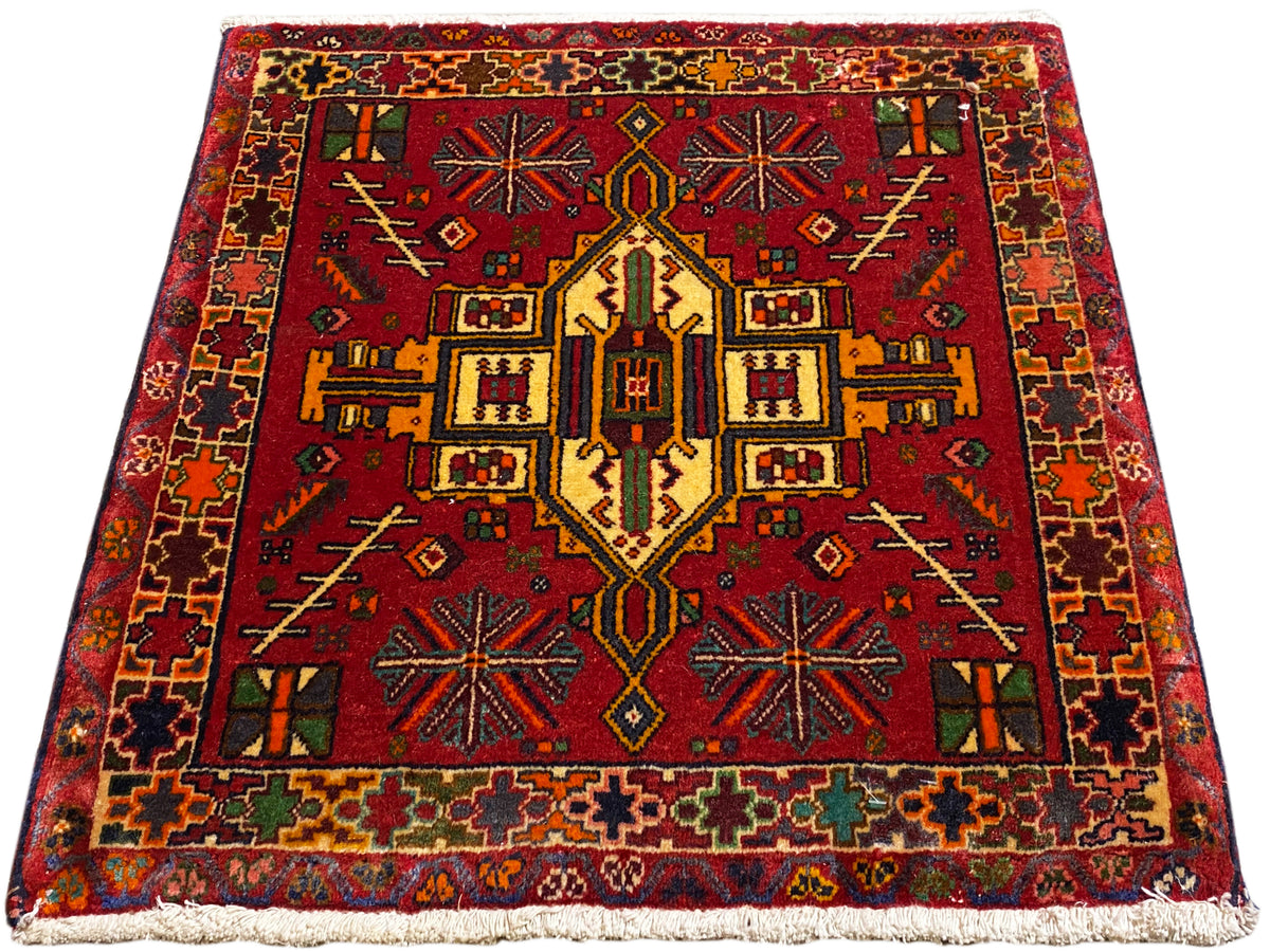 Poshti-tapijt in rood met symmetrisch centraal patroon en veelkleurige rand