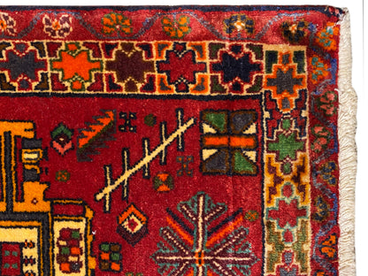 Close-up: Poshti rug with a red ground, colorful ornaments and a multicolored border