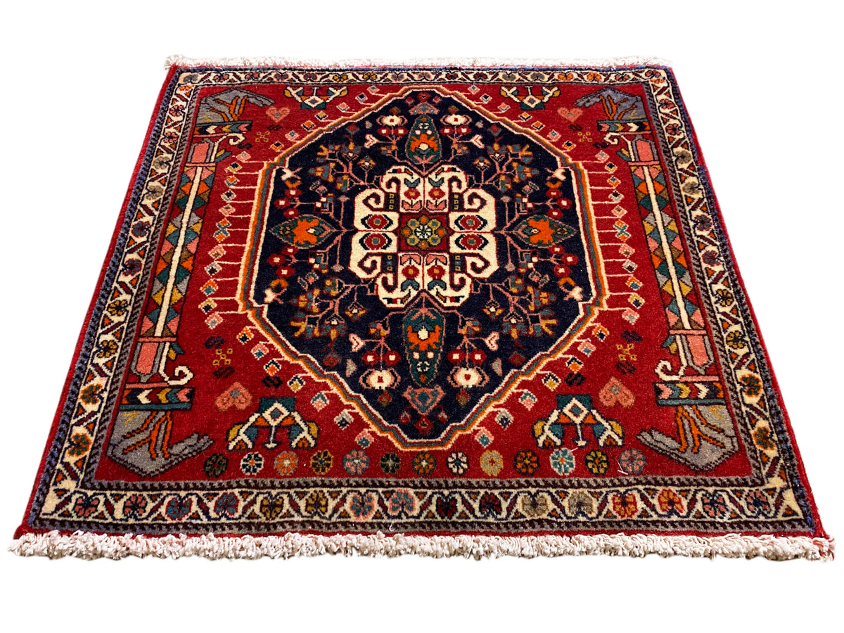 Tapijt met rode ondergrond, donkerblauw medaillon, symmetrisch ornament, rechthoekig