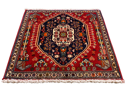 Tapijt met rode ondergrond, donkerblauw medaillon, symmetrisch ornament, rechthoekig