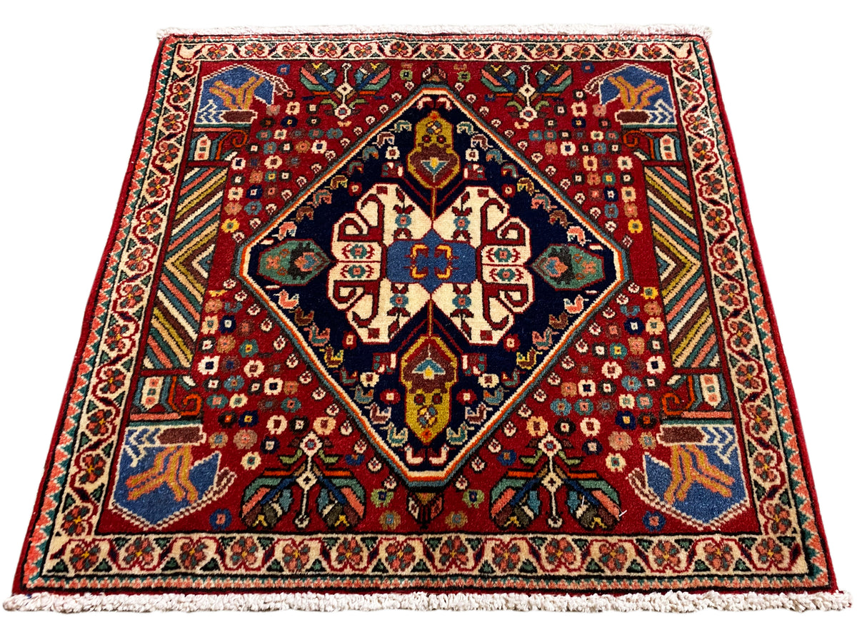 Tapijt 66x62 cm met rood patroon, donkere rand en kleurrijke ornamenten