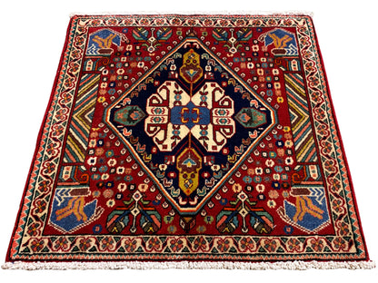Tapijt 66x62 cm met rood patroon, donkere rand en kleurrijke ornamenten