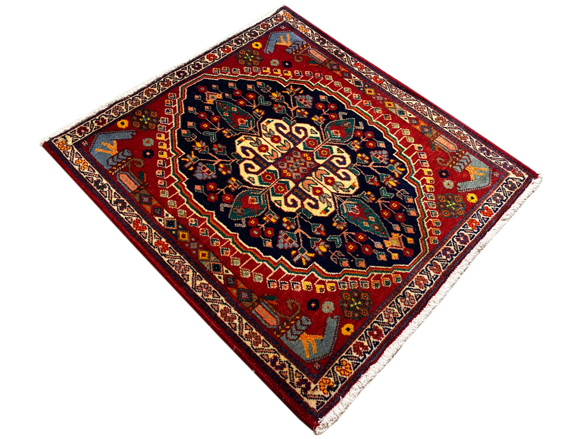Tapijt 67x60 cm, vierkant, rood basisvlak met donkerblauw-gouden centraal ornament.