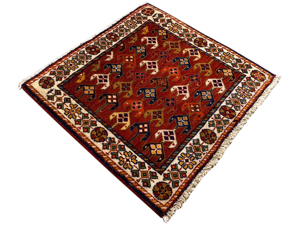 Tapijt van 61x61 cm met een rode basis en kleurrijke geometrische patronen, rondom voorzien van een rand