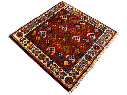 Tapijt van 61x61 cm met een rode basis en kleurrijke geometrische patronen, rondom voorzien van een rand