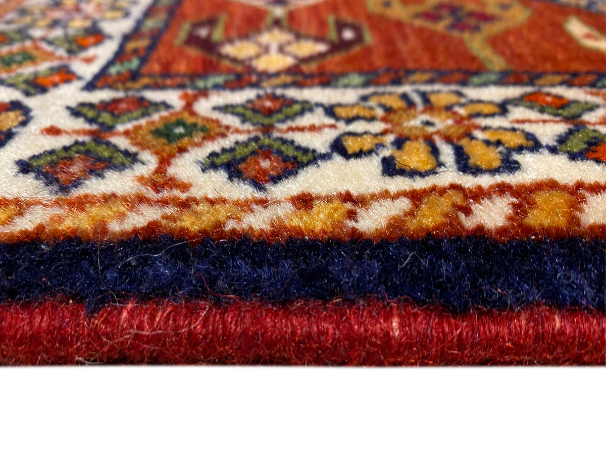 Tapijtrand met rode pool, donkere zoomrand en decoratieve patroonstrook