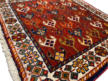 Tapijt met rood patroonvlak, blauw-turquoise rand en rafelige afwerking