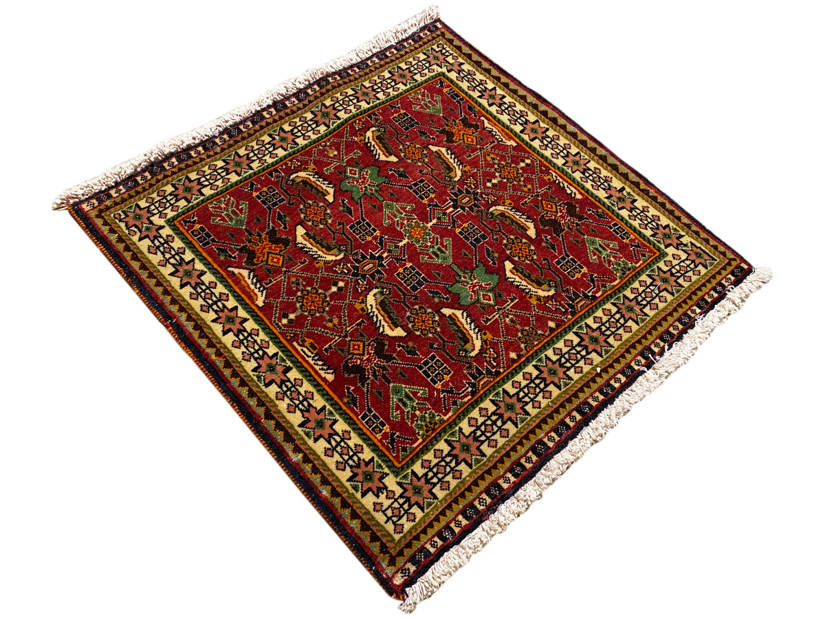 Poshti-tapijt 63x61 cm, diagonale weergave: rood patroon met groene details, franjes.