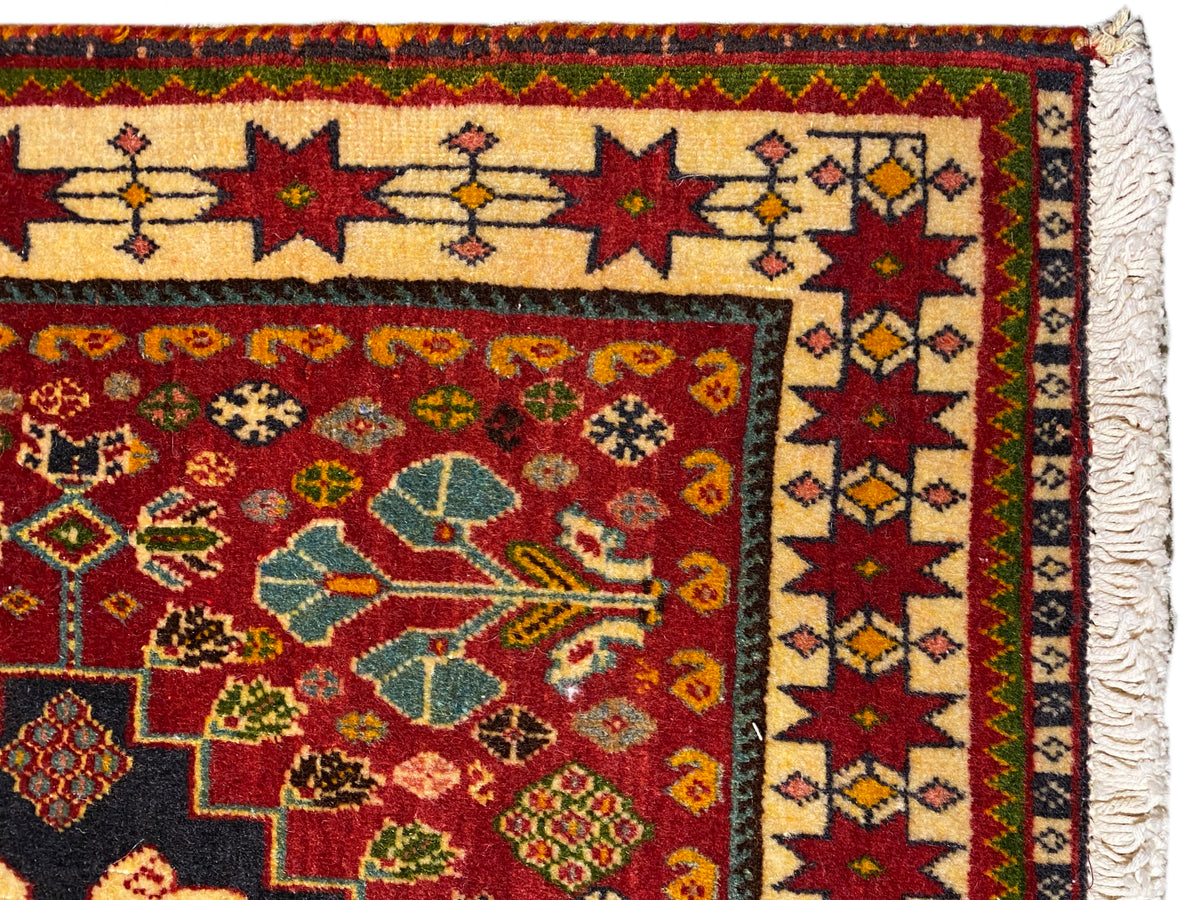 Tapijt in detail: veelkleurige rand en ornamentmotieven, franjerand aan de zijkant