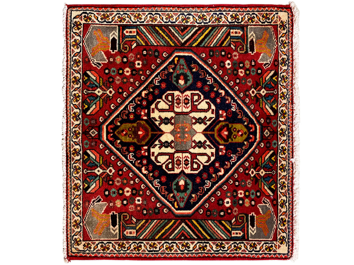 Oosters tapijt met rode ondergrond, donkerblauw medaillon en geometrische ornamenten