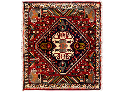 Oosters tapijt met rode ondergrond, donkerblauw medaillon en geometrische ornamenten