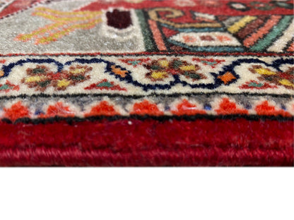 Close-up: rug edge with fringes, red finish and dense ornamental pattern