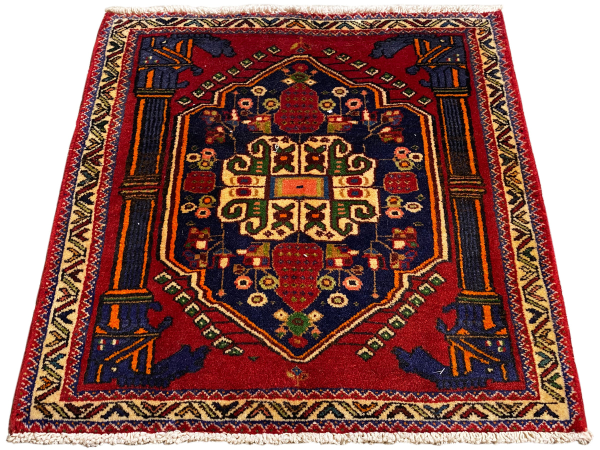 Poshti-tapijt 66x62 cm plat uitgespreid: rood centraal medaillon met geometrische ornamenten.