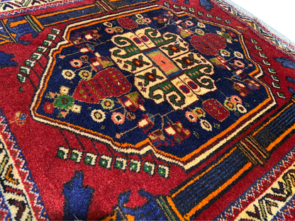 Poshti-tapijt 66x62 cm Detail: rood centraal patroon, blauw veld en kleurrijke sierlijnen.