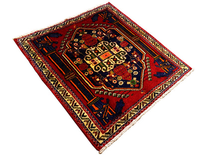 Poshti-tapijt 66x62 cm uitgevouwen: rood binnenveld met geometrisch patroon en hoekmotieven.