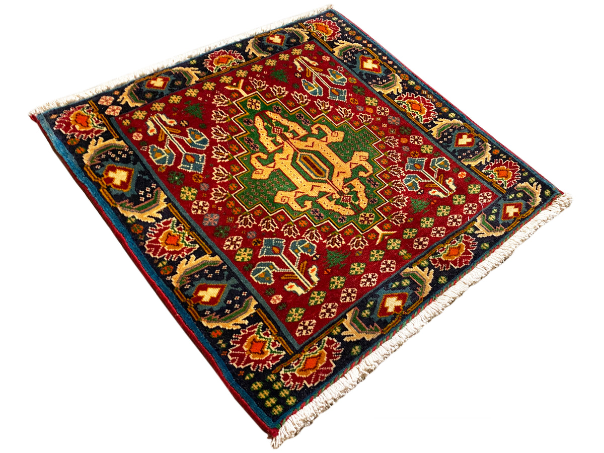 Rechthoekig tapijt (67x66 cm), diagonaal gefotografeerd; rood veld, donkere rand, franjes