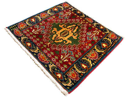 Rechthoekig tapijt (67x66 cm) met rood centrum, donkere rand en veelkleurige ornamenten, franjes