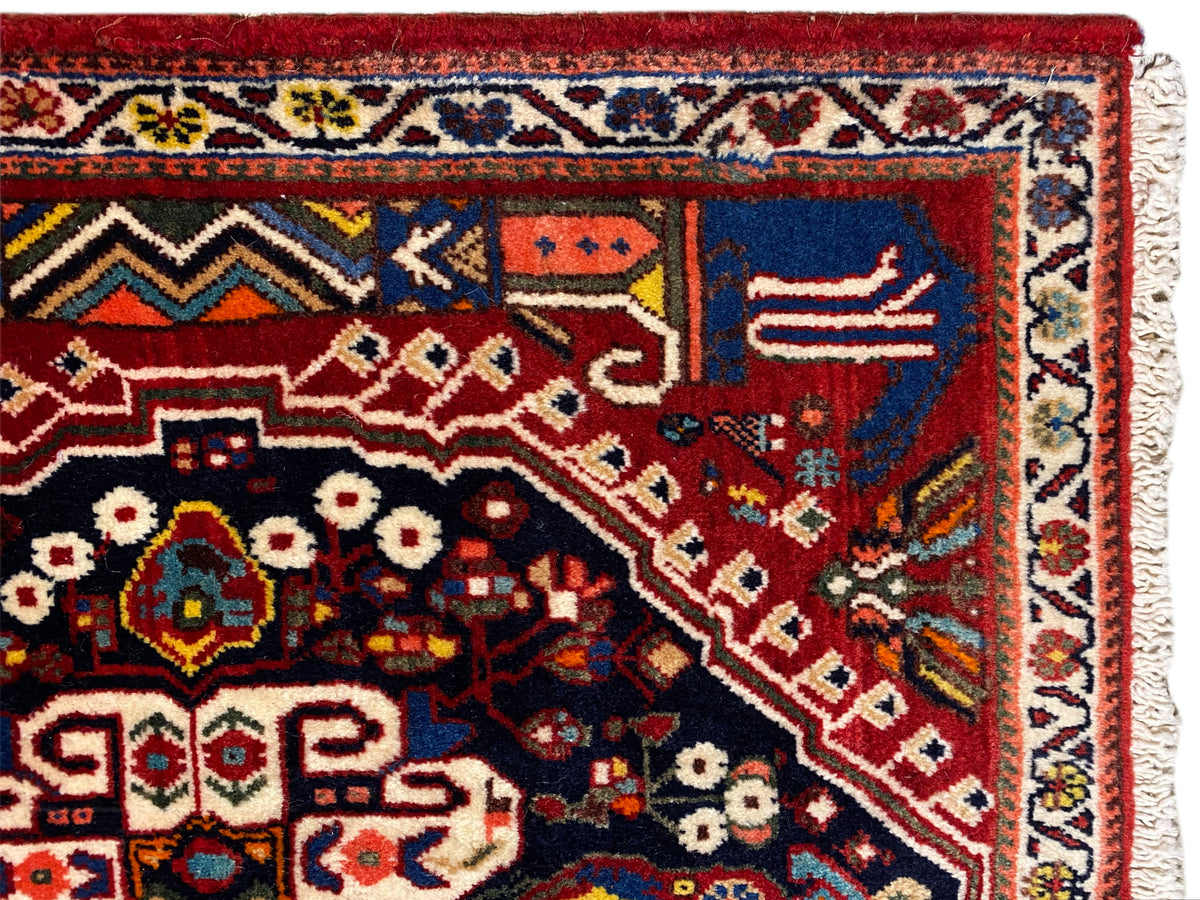 Detailweergave van het tapijt: rode achtergrond, donkerblauw vlak, ornamenten en rand、】【