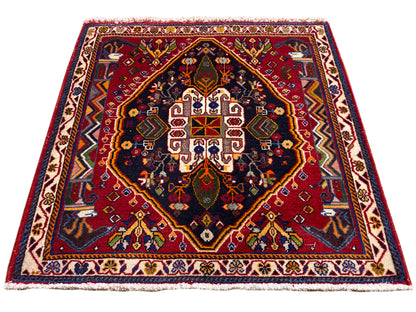 Poshti-tapijt (67×67 cm) in schuin aanzicht: rand, rood midden, donkerblauw