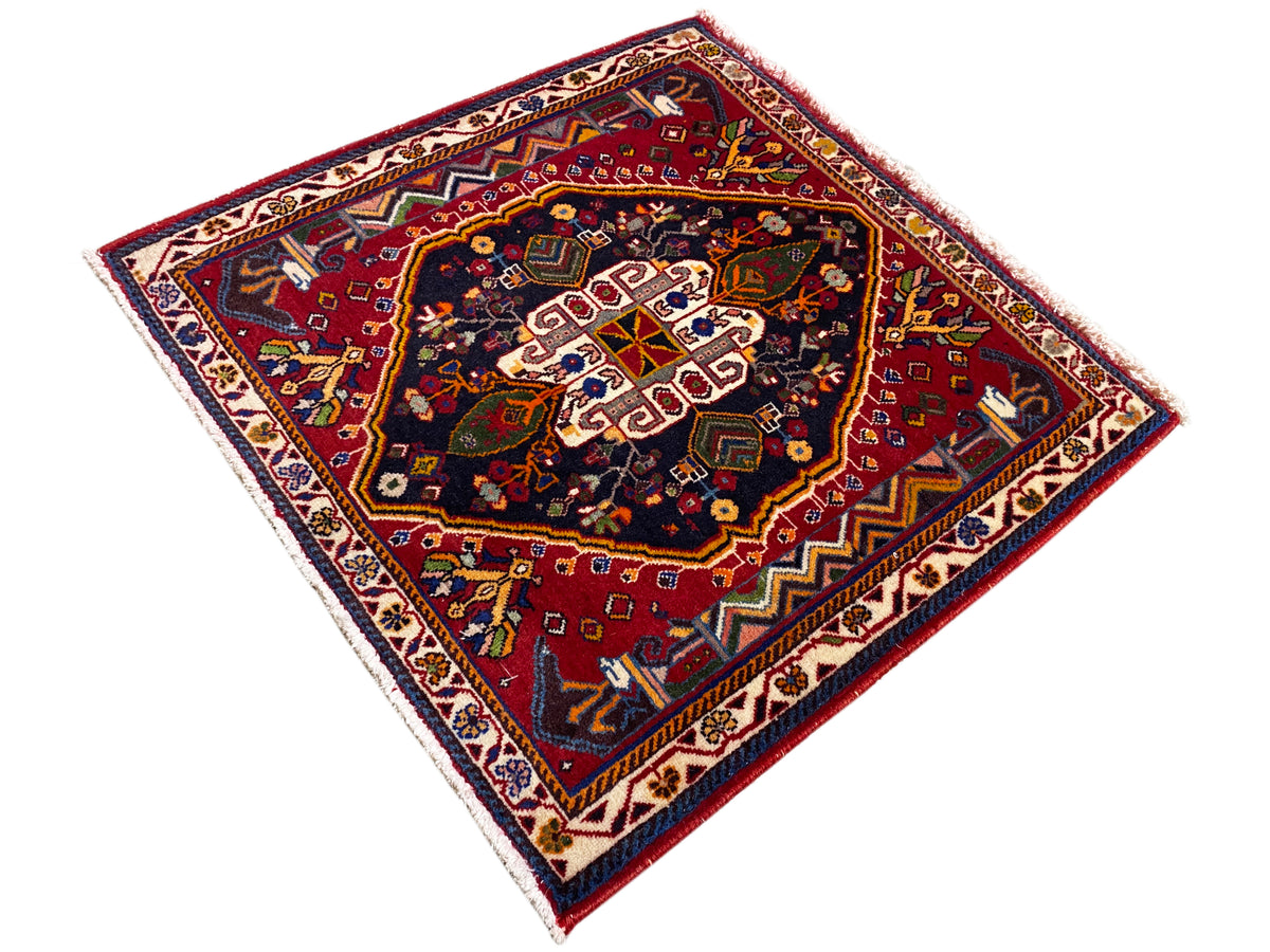 Poshti-tapijt (67×67 cm) diagonaal: rode ondergrond, donker centrum met witte patronen