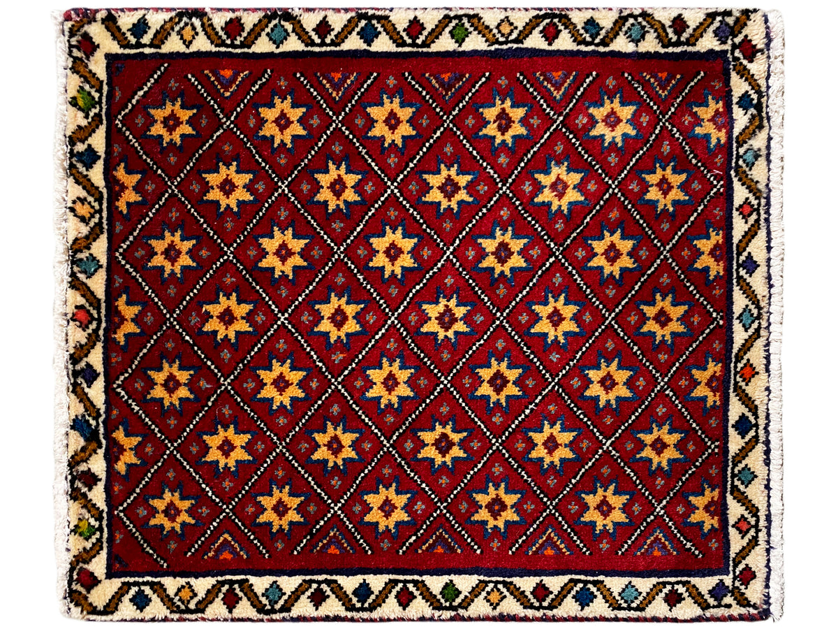 Vierkant vloerkleed met rood motief en veelkleurig geometrisch tegelsterpatroon