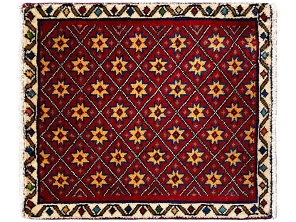Vierkant vloerkleed met rood motief en veelkleurig geometrisch tegelsterpatroon